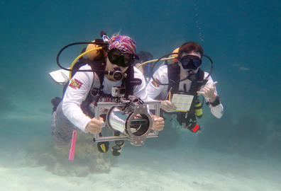 Two scuba divers operating a special camera to measure fish lengths as part of the SMILE project.